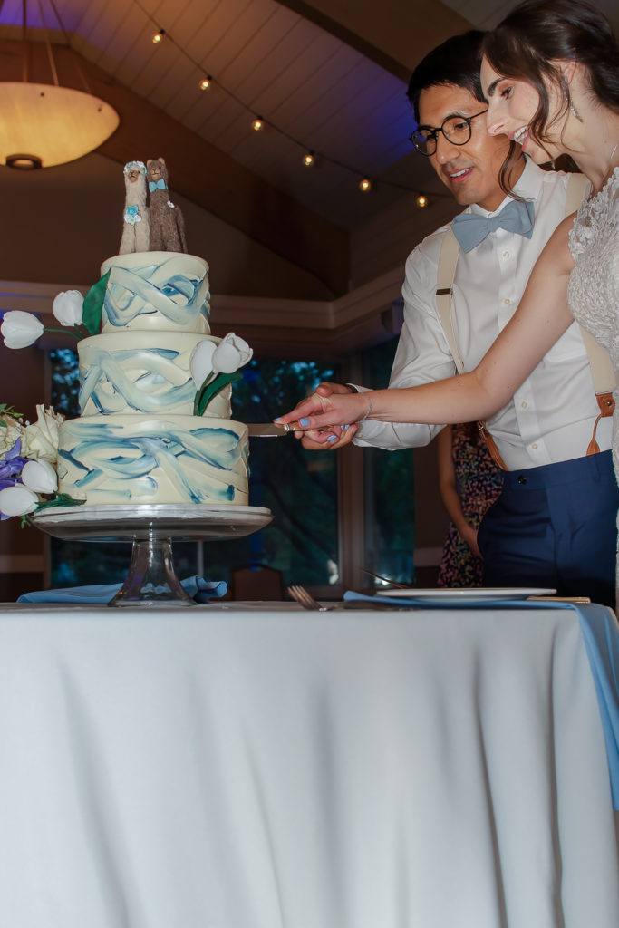 photo of bride and groom cutting cake during wedding reception