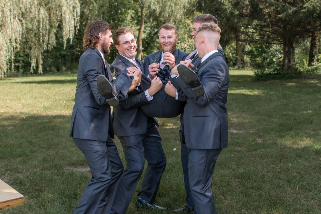 photo of groomsmen throwing up groom