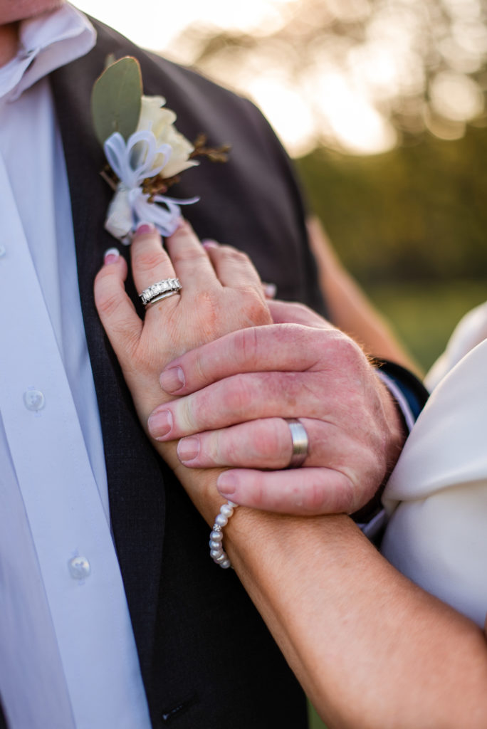 photo of bride and groom's hands with their wedding rings