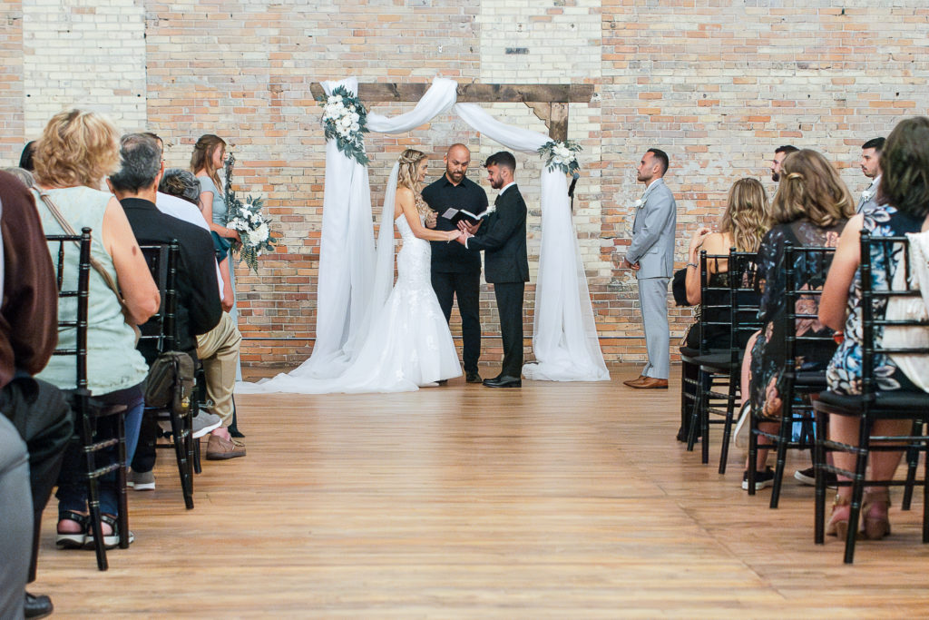 bride and groom hold hands during wedding ceremony