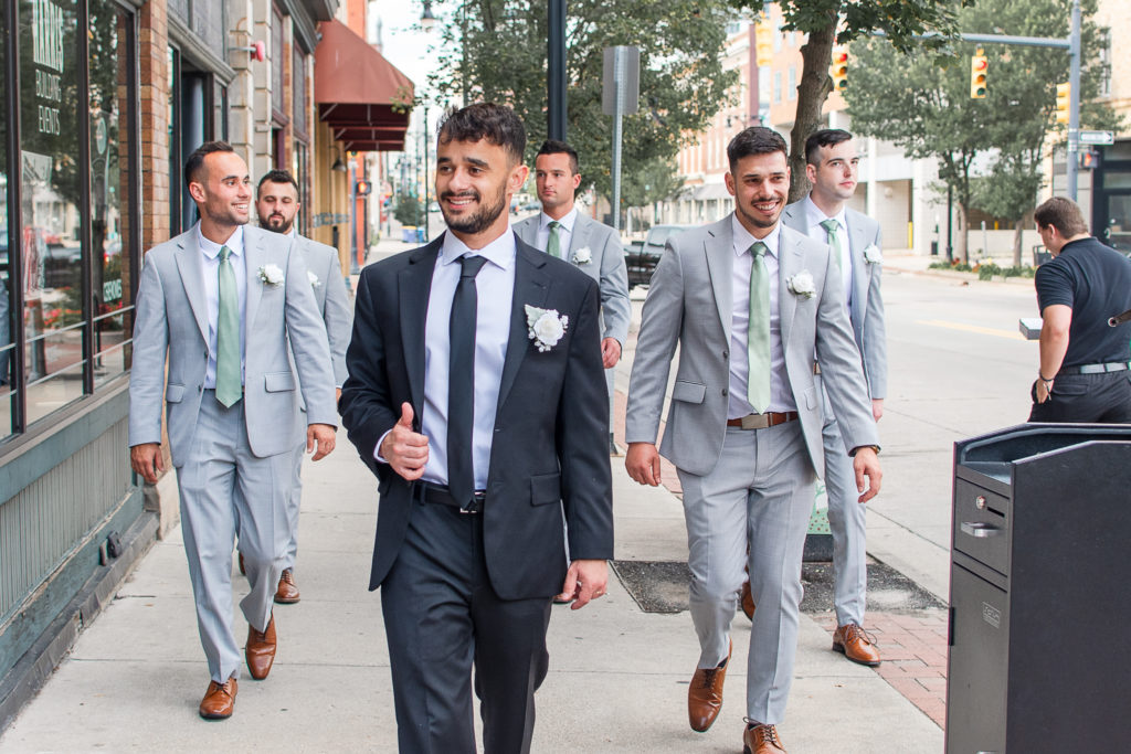 photo of groom walking with his groomsmen on wedding day