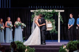 bride and groom's first kiss during wedding ceremony