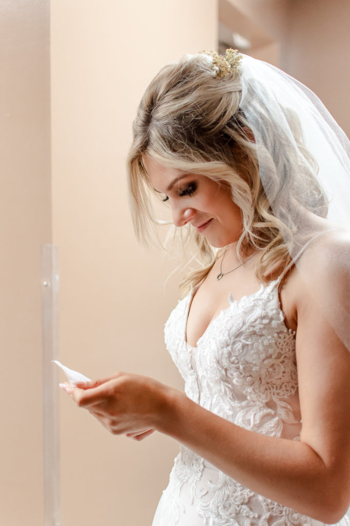 bride reading letter from groom before wedding ceremony