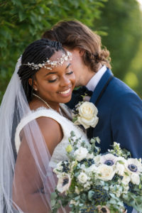 portrait of groom nuzzling bride during wedding day