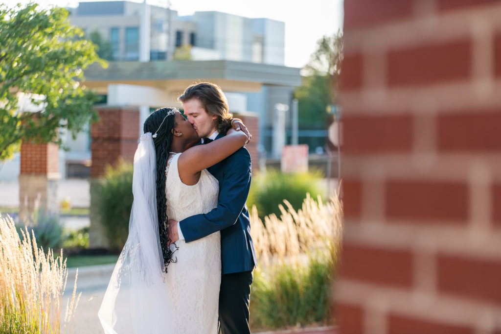 bride and groom kissing downtown on wedding day