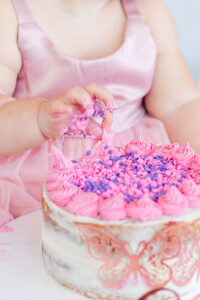 photo of baby's hand and cake during cake smash session