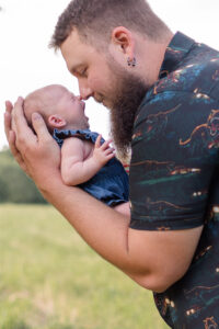 photo of dad holding baby during newborn photo session